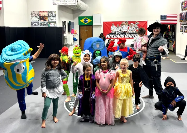 A group of children in costume on the mats at the academy