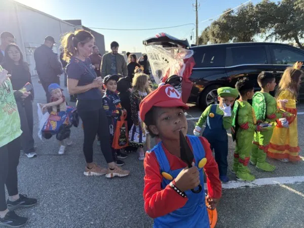 Children in costume lining up for candy at a past Trunk or Treat